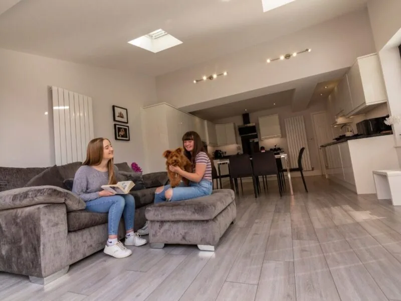 Family dog sitting with owner at home